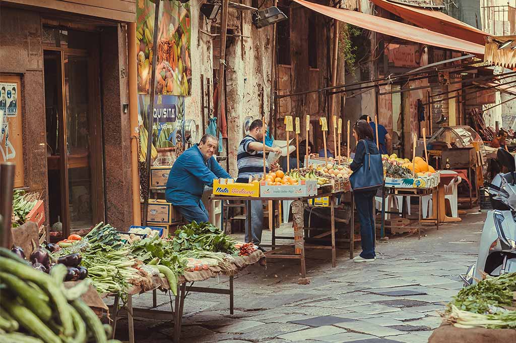 Una mujer hace su compra en un mercado en Italia.