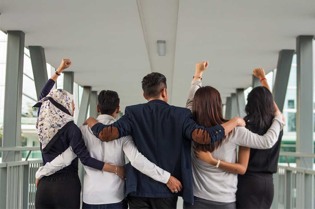 Equipo en un abrazo grupal, mostrando unidad.