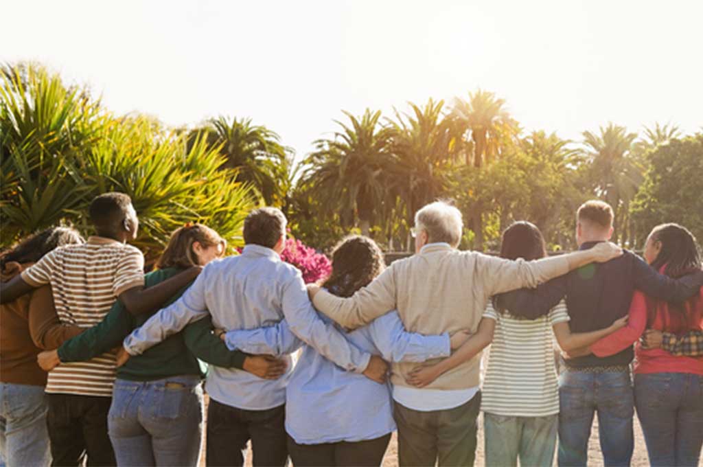 Personas multigeneracionales felices y abrazadas en un parque.