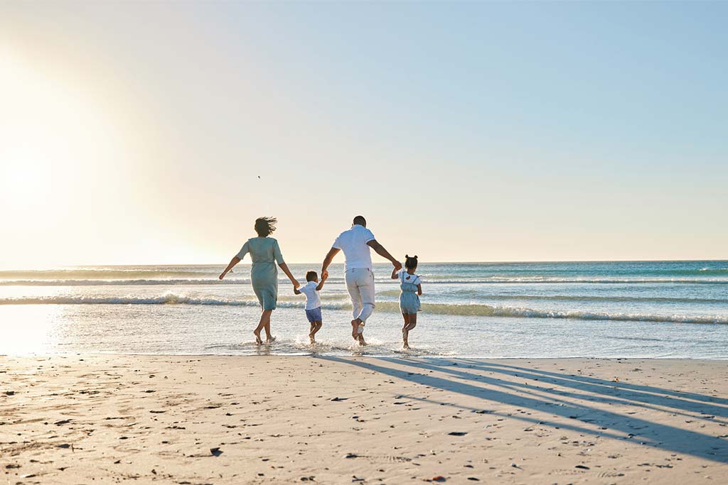 Happy family walking on the beach.